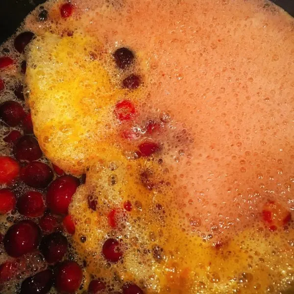 Cranberry Orange Rum Syrup boiling in the sauce pan on the stove.