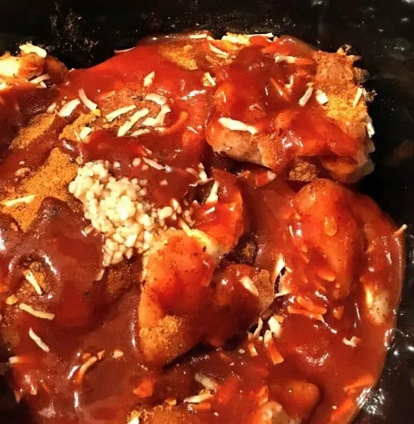 Adding garlic and and enchilada sauce to slow cooker chicken tacos