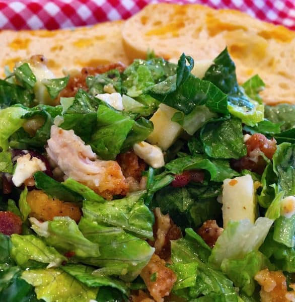 a green salad with chicken, bacon, apples and cheddar cheese