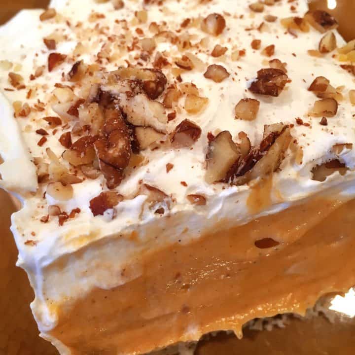 Pumpkin Layered Lush with layers of cream cheese, pumpkin filling, whipped cream and a pecan crumb crust.