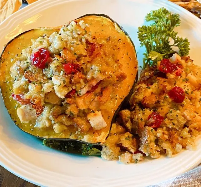 Stuffed Acorn Squash in a bowl setting on the table.