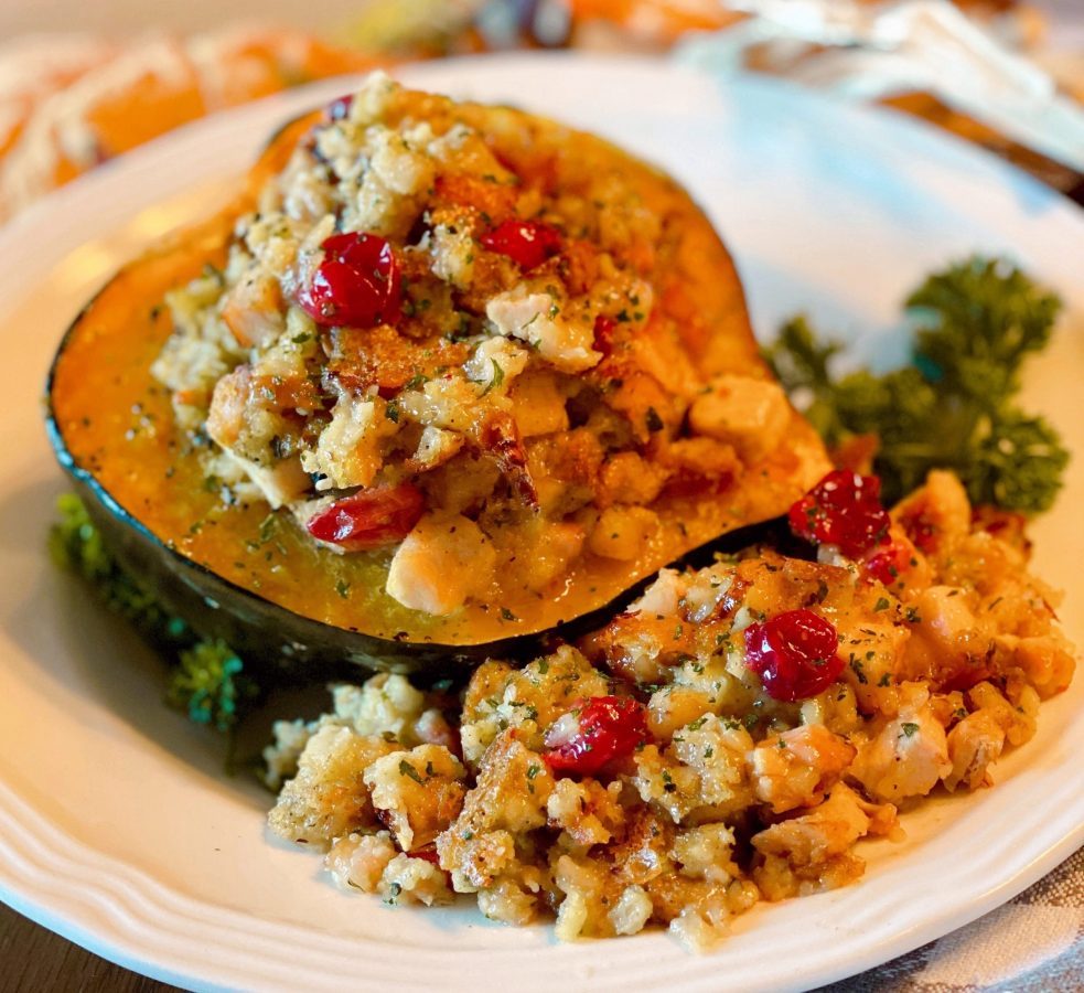 Stuffed Acorn Squash on a plate with extra stuffing around it.