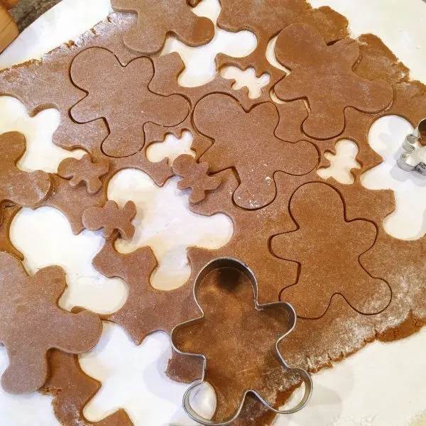 Spiced Gingerbread men on dough disc being cut out