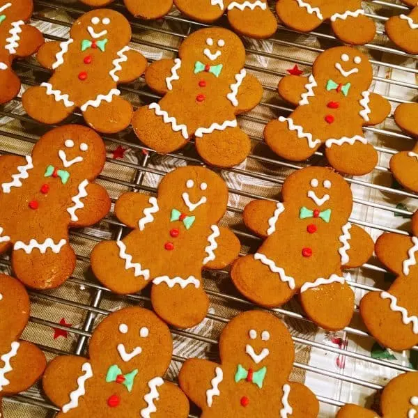 Spiced Gingerbread men on cooling rack decorated with royal icing