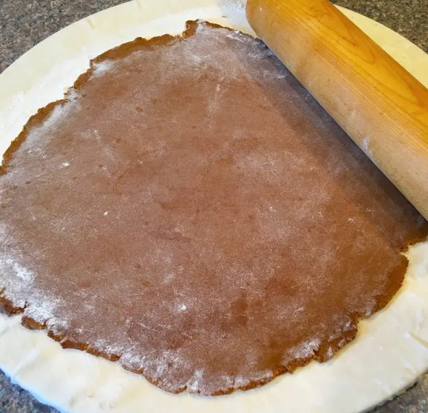 Spiced Gingerbread Men Cookie dough rolled out on a floured dough disc