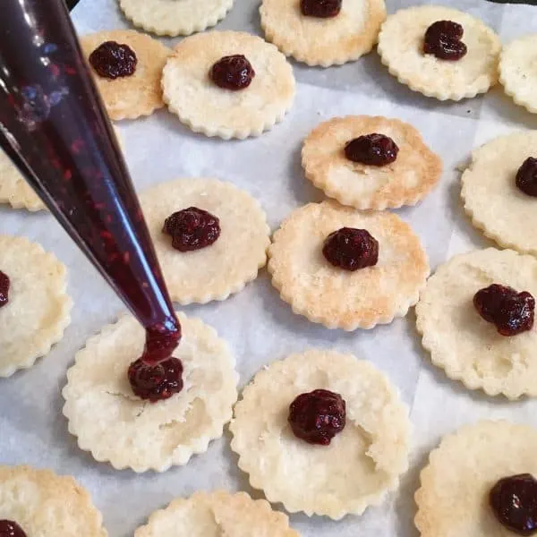 Linzer Cookie with Raspberry filling being pipped into center