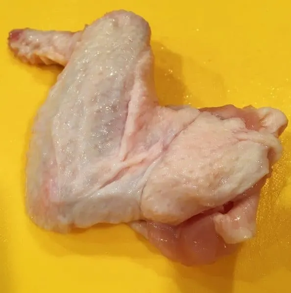 Raw Chicken wing on a cutting board