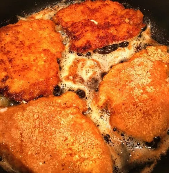 Fried chicken breast in the skillet.