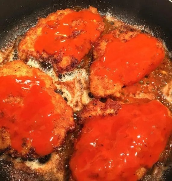 Fried chicken breast with Buffalo sauce drizzled over them