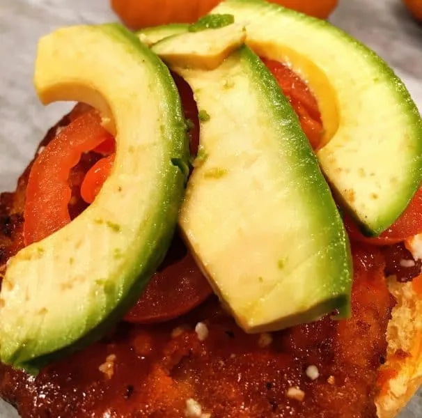 sliced avocado and tomato on top of chicken