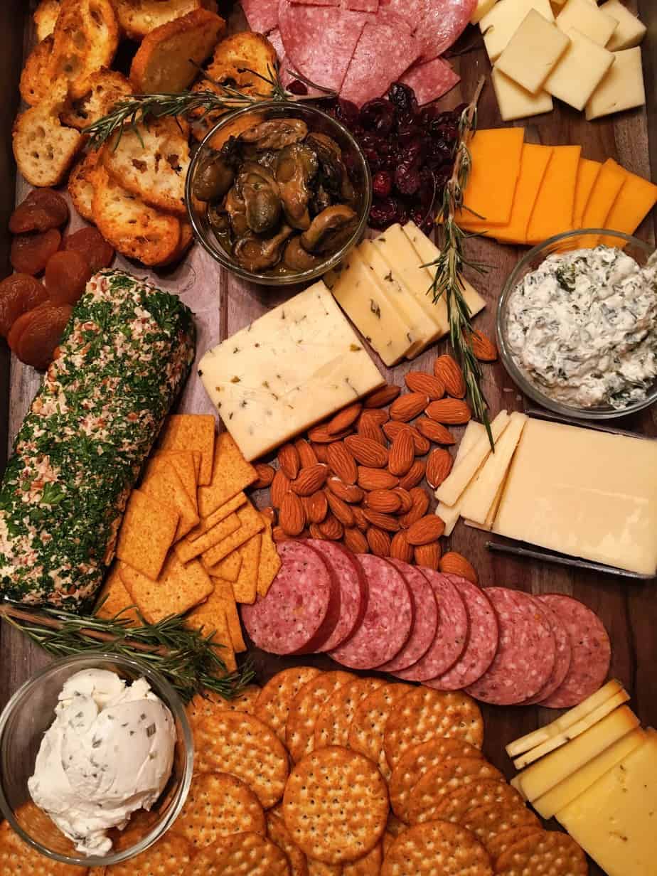 A board with various cheeses, crackers and crackers