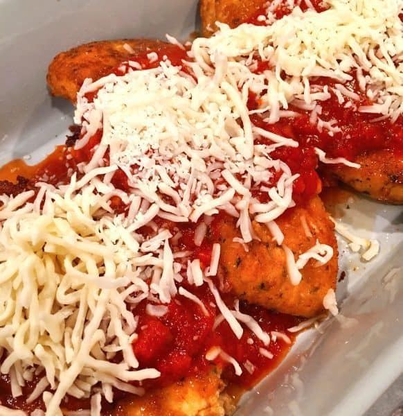 fried chicken breasts covered with marinara sauce and grated cheese