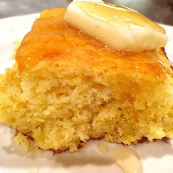 A slice of delicious corn bread with a piece of butter on top