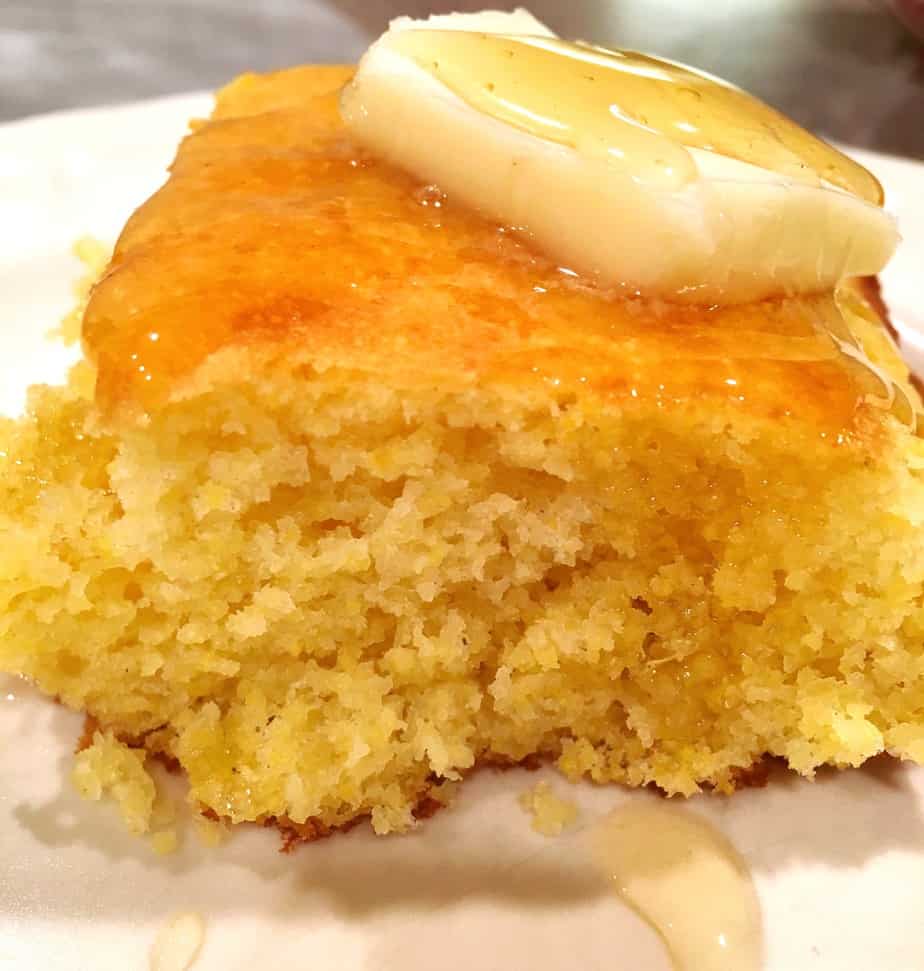 A slice of delicious corn bread with a piece of butter on top