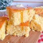 Upclose photo of stacked moist cornbread with a heavy drizzle of honey and a pat of melted butter.
