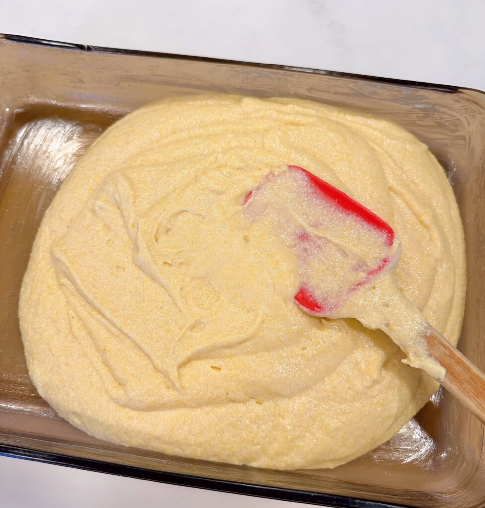 Cornbread batter poured into prepared 9x13 glass baking dish.