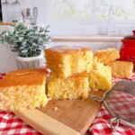 Stacked butter cornbread on a wooden cutting block.