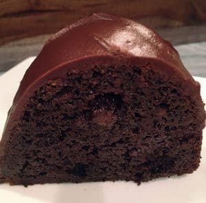 A delicious piece of chocolate cake with a chocolate frosting on top