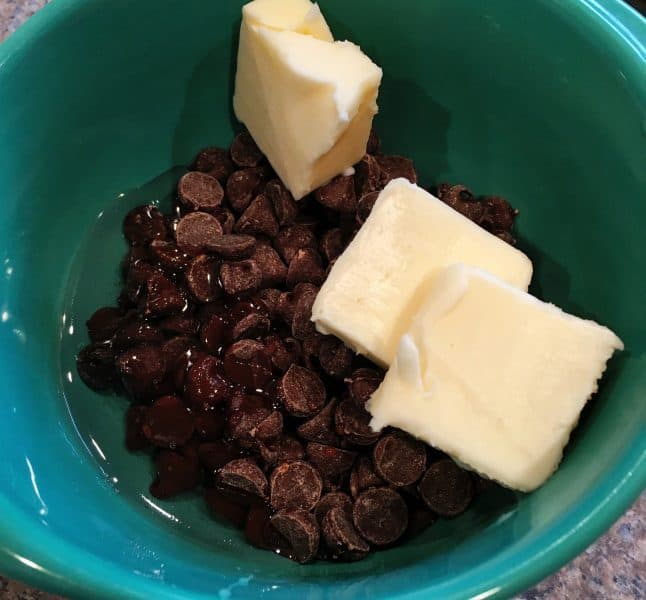 Chocolate Satin Glaze ingredients in a bowl with chocolate chips, syrup, and butter ready for microwave