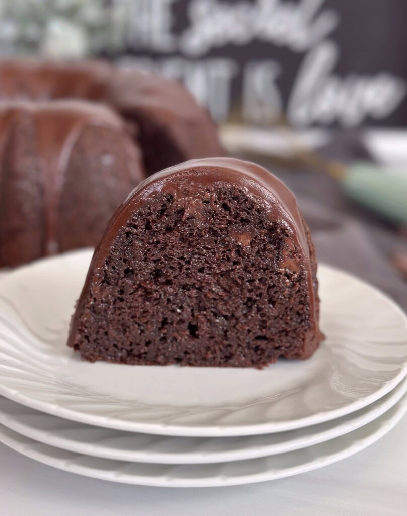 One slice of too much chocolate cake on a stack of dessert plates.