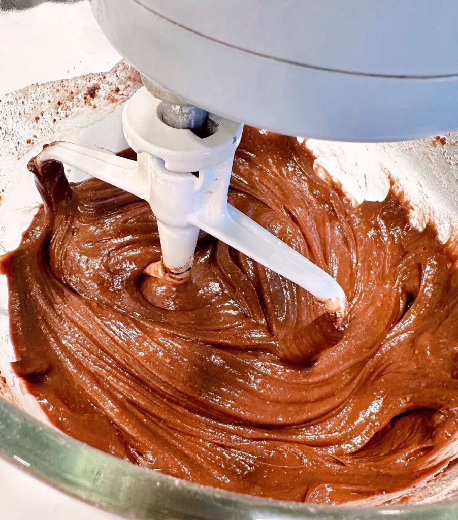 Cake batter in a mixing bowl with a paddle.