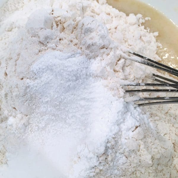 adding dry ingredients to blueberry muffin batter