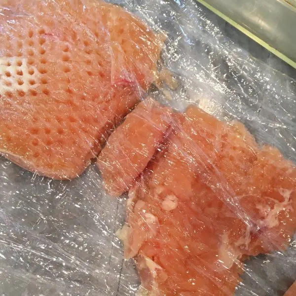 Chicken Breast tenderized between sheets of plastic wrap