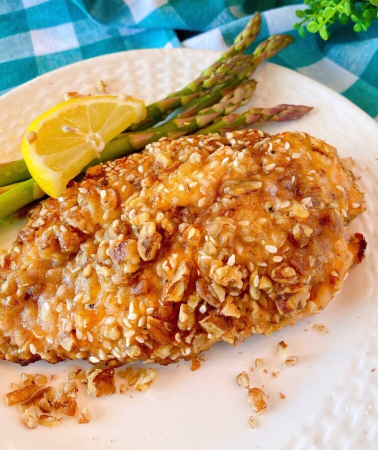 Pecan Chicken on a plate with asparagus