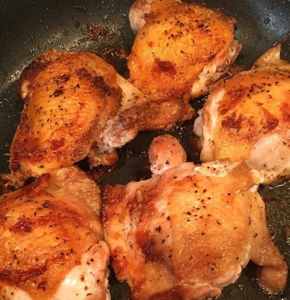 Browned Chicken thighs in a hot skillet