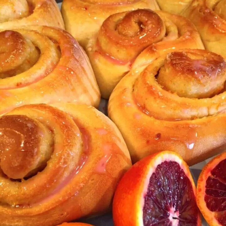 Blood orange sweet rolls in a pan with blood oranges.