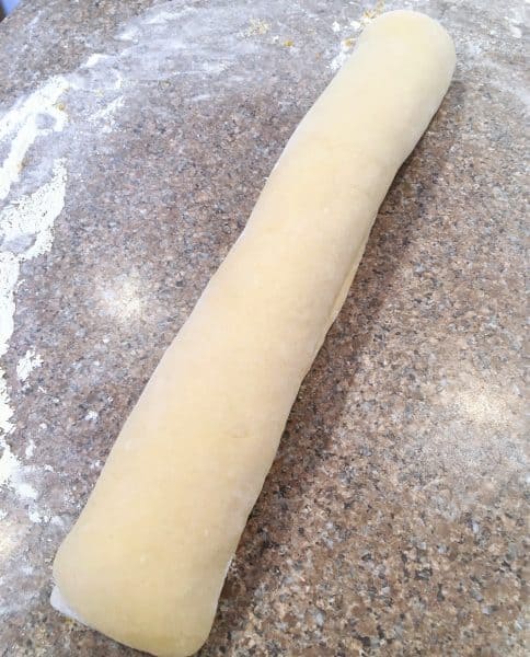 Dough for Orange Rolls rolled into a large log ready to cut into rolls