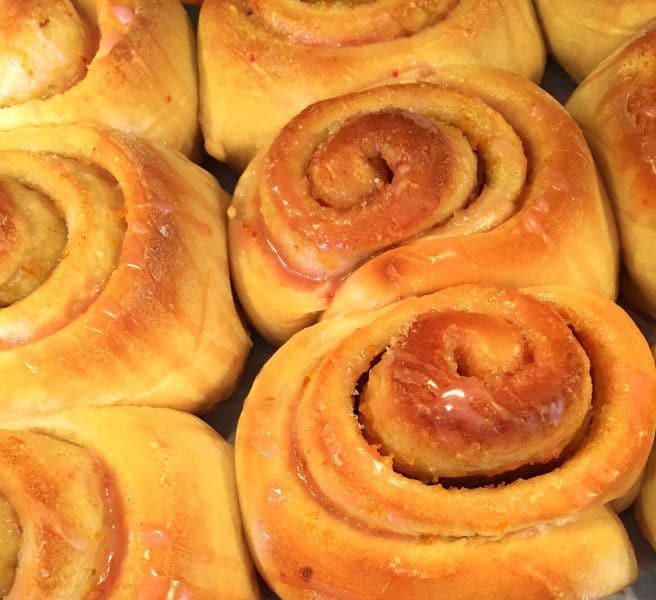 Orange Rolls baked and drizzled with orange glaze in baking pan