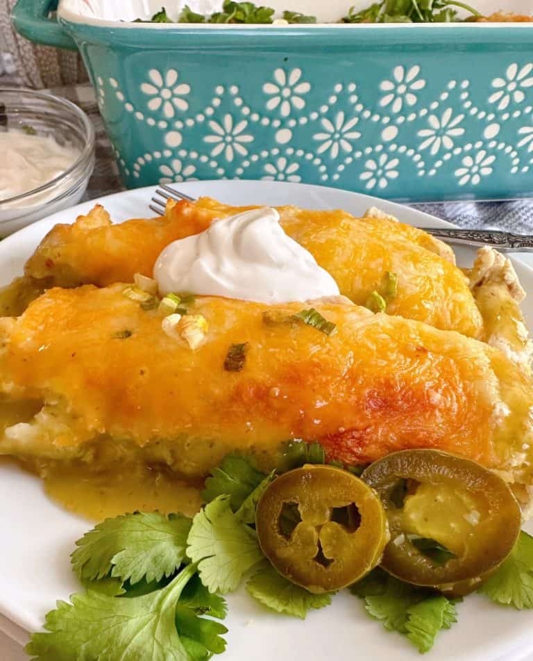 White enchiladas with sour cream on a white plate.