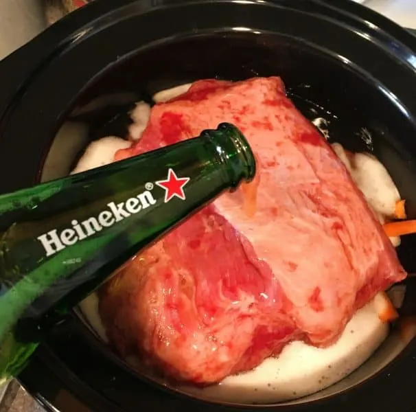 Adding beer to the corn beef in the slow cooker. 