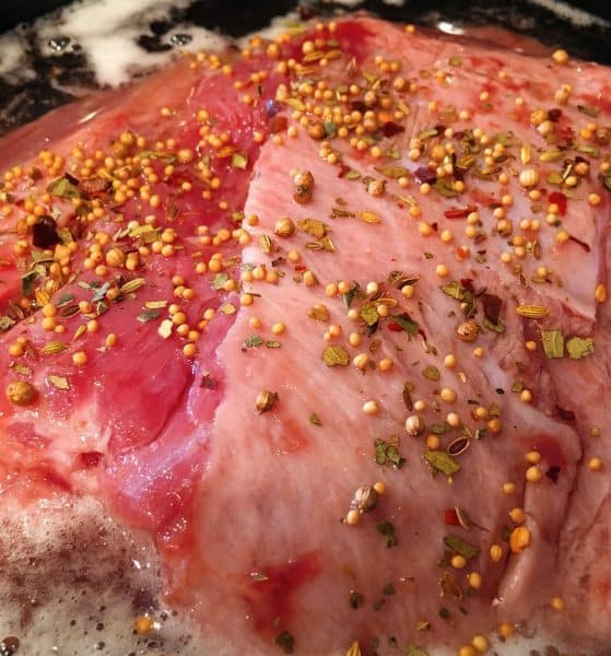 Spices and seasonings on top of the Corn Beef in the slow cooker