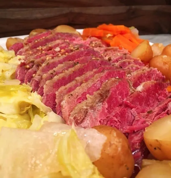 Platter fun of sliced corn beef with potatoes, carrots, and cabbage.