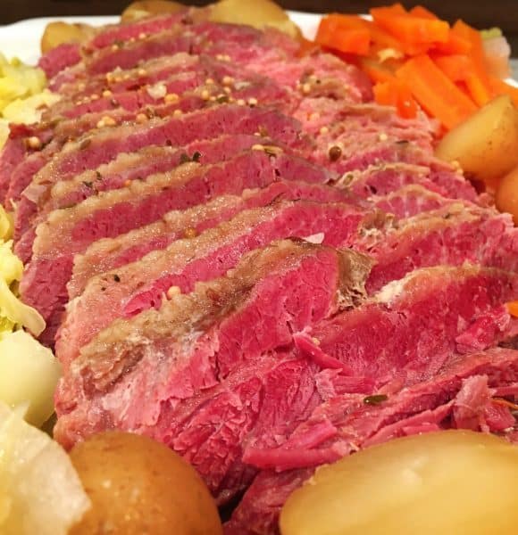 Sliced Corn Beef with potatoes, carrots, and cabbage.