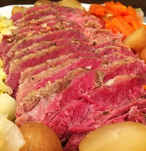 Sliced Corn Beef with potatoes, carrots, and cabbage.
