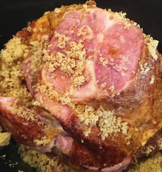 Ham in the slow cooker with brown sugar and peach glaze ready to cook.