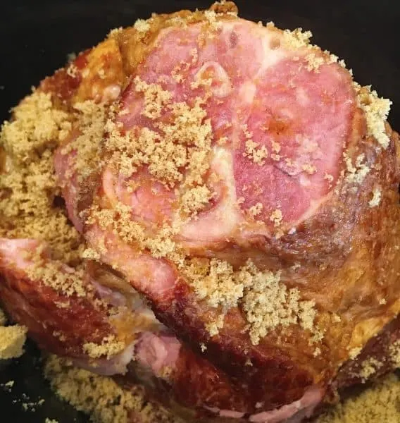 Ham in the slow cooker with brown sugar and peach glaze ready to cook.