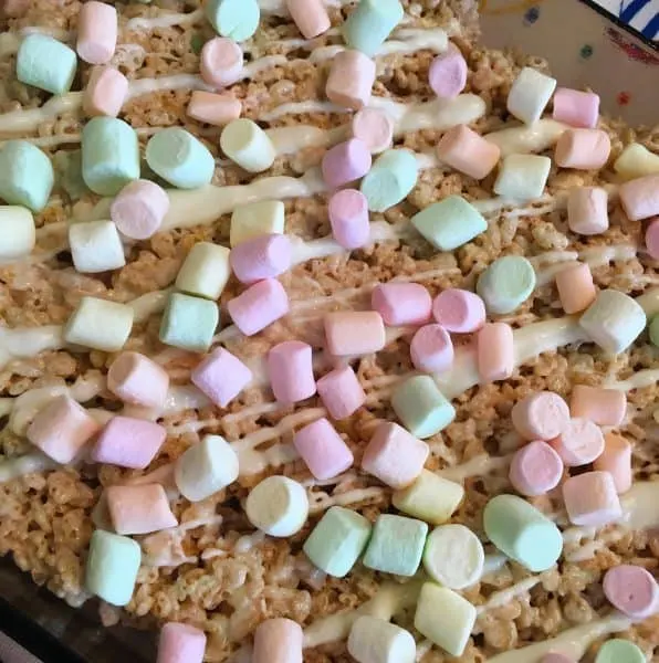 Rice Krispie treats drizzled with white chocolate and small pastel marshmallows