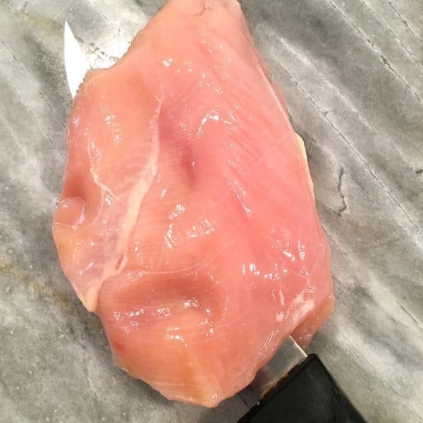 Chicken breast being fillet.