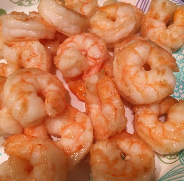 Cooked shrimp draining on a paper plate