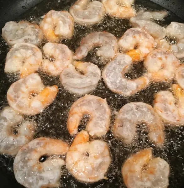 Shrimp frying in a skillet in oil for Shrimp Noodle dish