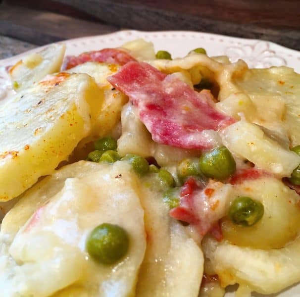 Ham, Pea, and Potato Casserole in a creamy white sauce on a white plate