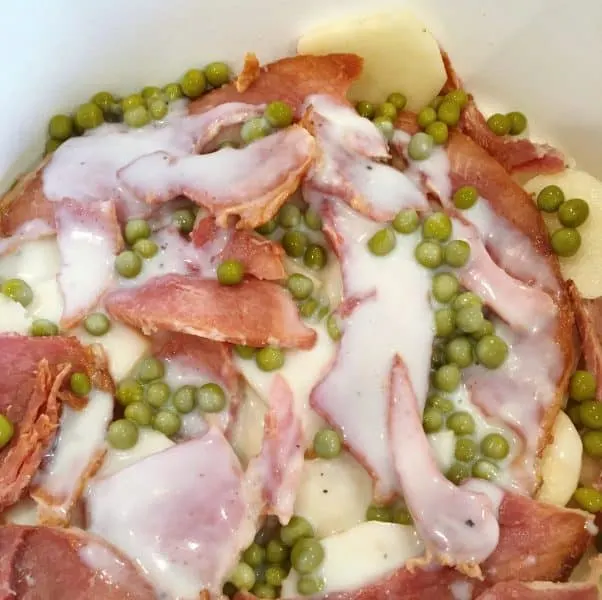 Add the White Cream Sauce over the peas, potatoes, and ham.