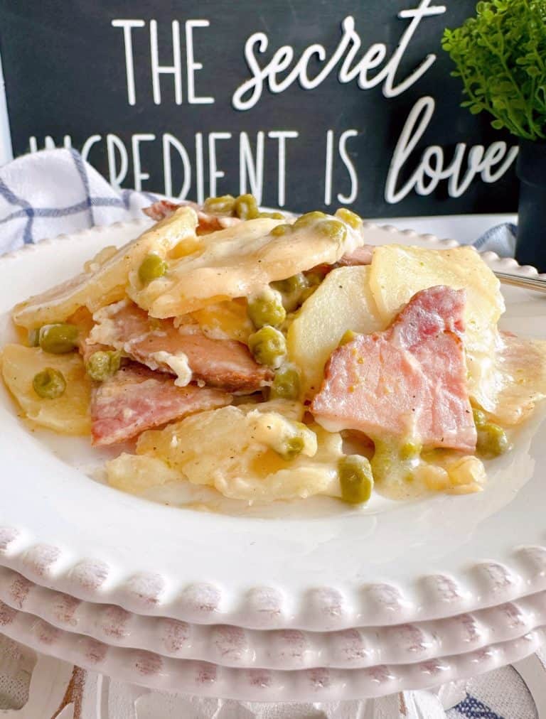 White serving plates with a serving of Ham and Potato casserole.