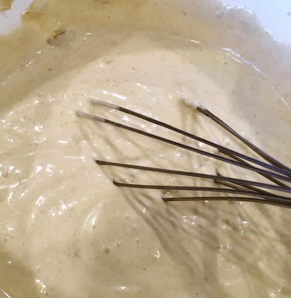 mixing the enchilada sauce together with a wire whisk.