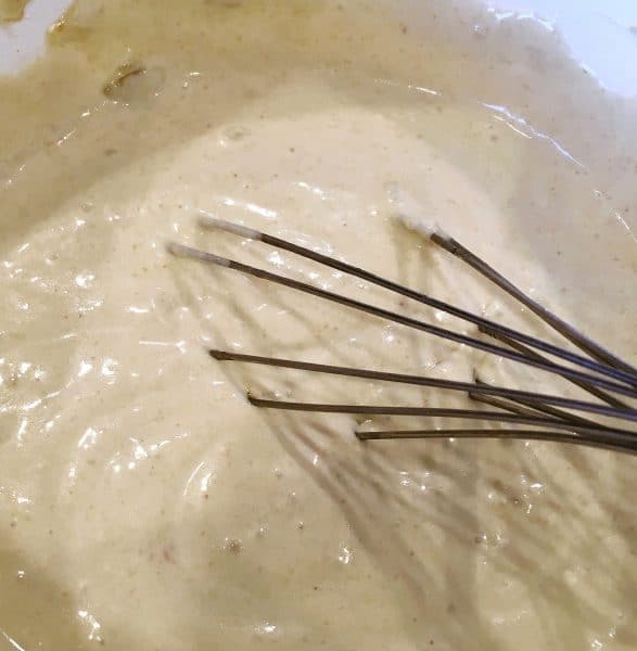 mixing the enchilada sauce together with a wire whisk.