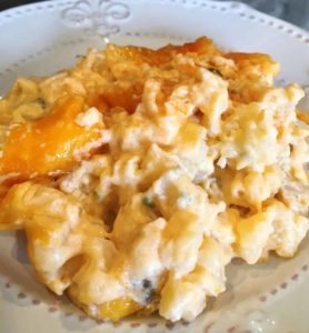 Cheesy funeral potato serving on a white dinner plate.